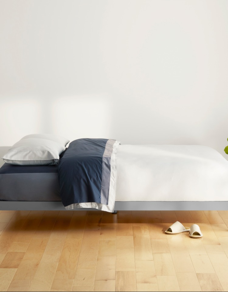 Grey platform bed and white-blue bedding on it