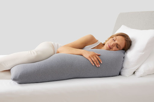 Woman sleeping with body pillow