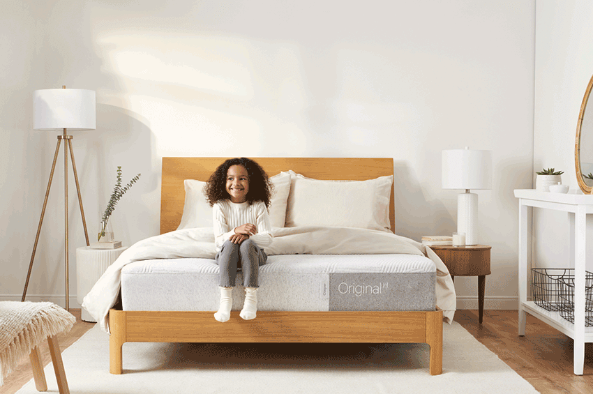 Wooden Casper bed frame with white mattress and comforter.