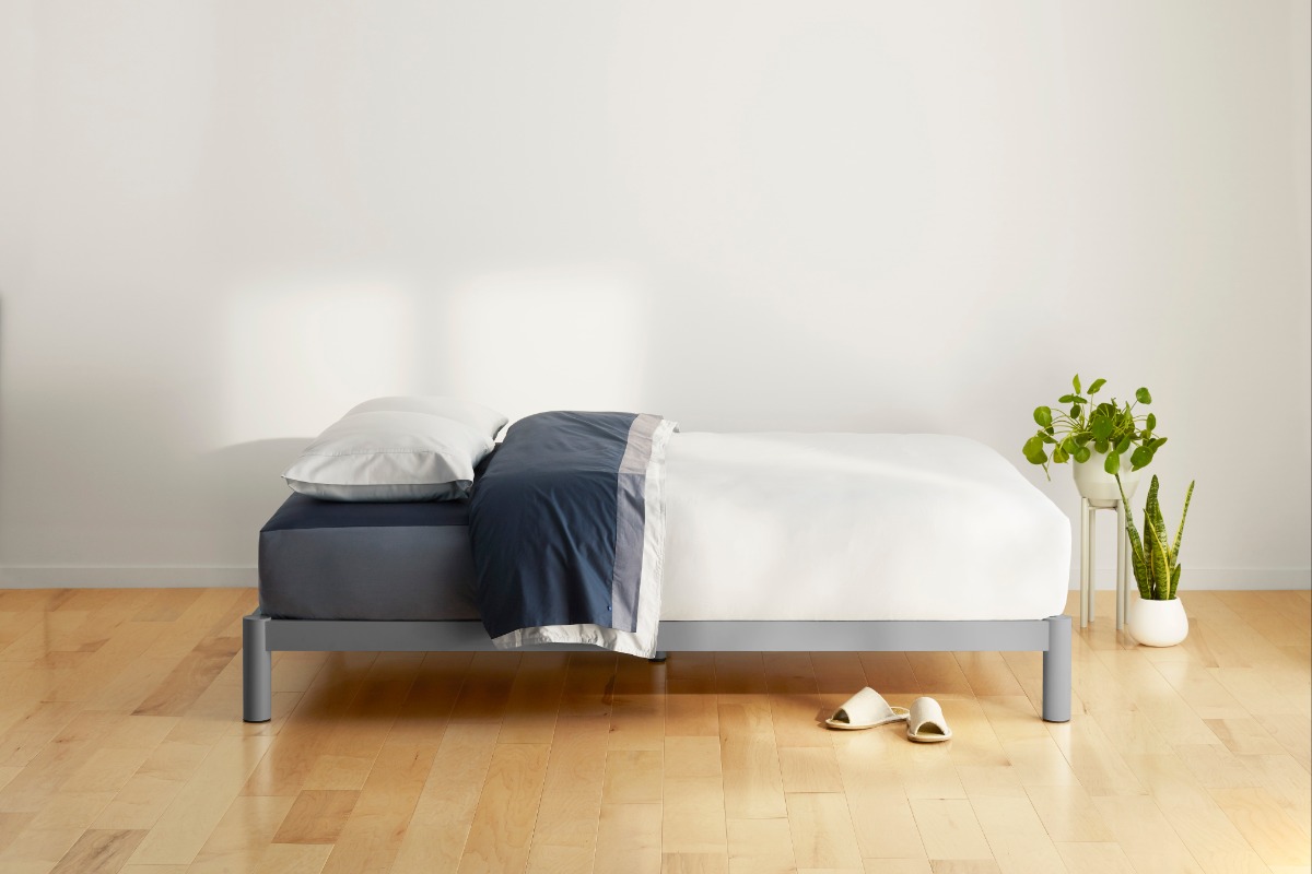 Grey platform bed and white-blue bedding on it